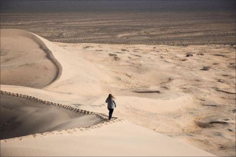 woman alone walking through a sand dune