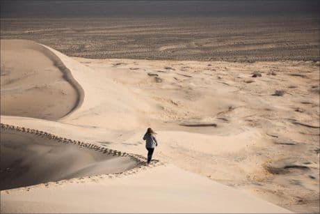 woman alone walking through a sand dune