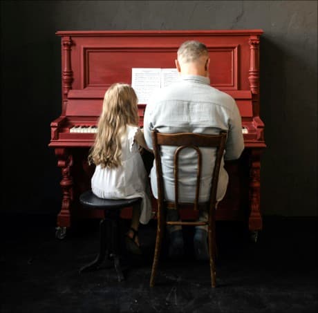 looking at 2 people at a piano