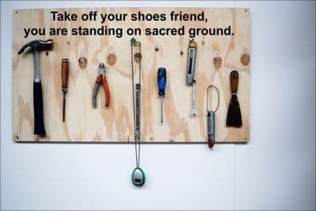 The Handyman's Philosophy tools in a workshop hanging on the wall.