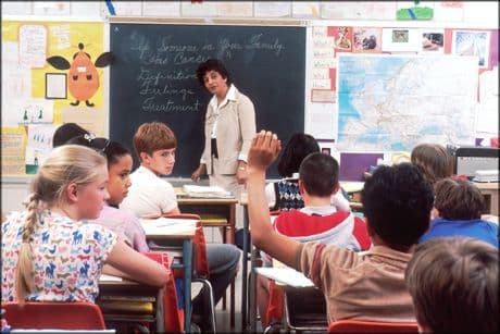The Teacher Who Made A Difference picture of a teacher asking a question to a group of young students