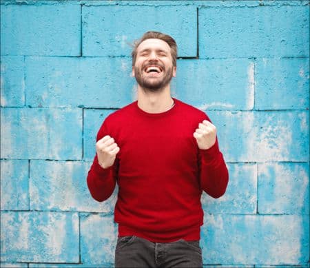 The Secret to Success MotivateUs man smiling with hands in the air